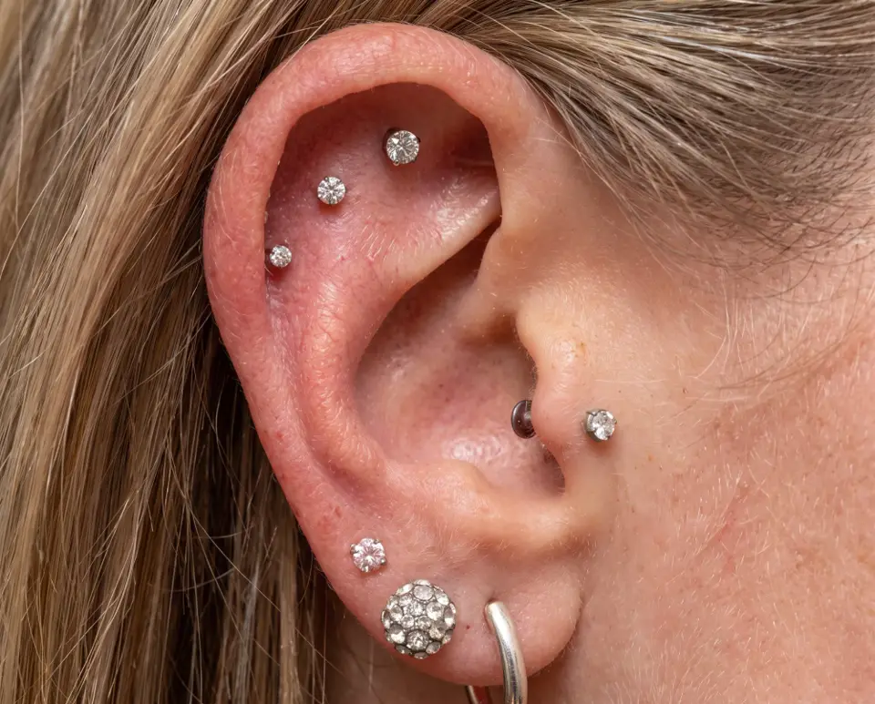 Curated ear with helix, tragus and lobe piercings in sparkling studs, the kind of Indianapolis piercings done at Grade A Castleton Square