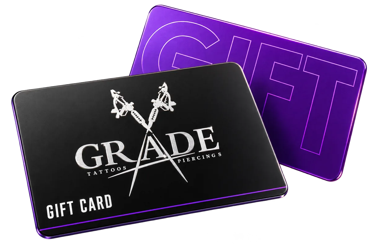 Three-dimensional Grade A gift cards in matte black and purple, featuring the Grade A Tattoos and Piercings logo