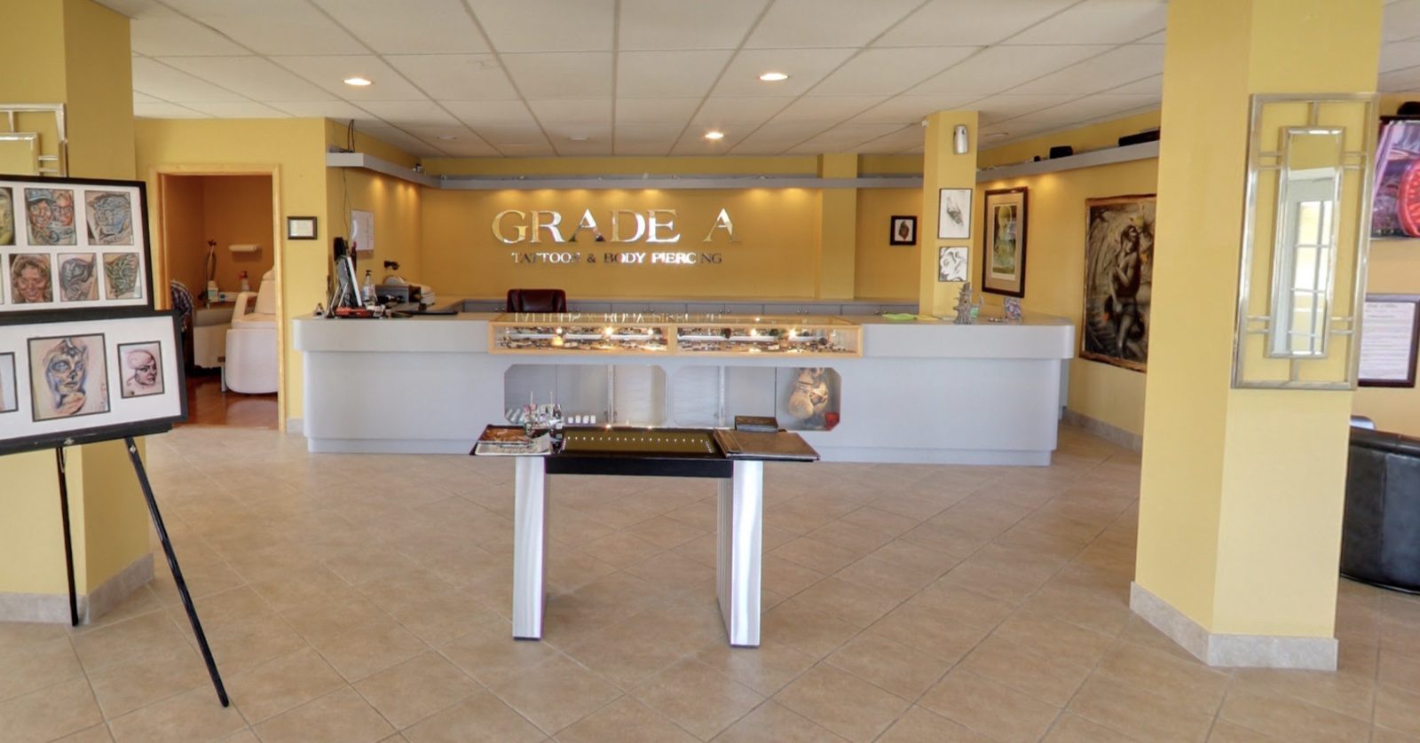 Grade A Tattoos reception area with a jewelry counter and artwork on display